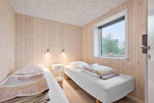 a bedroom with two beds and a window at 0180-Romo-Ejnar-Mikkelsensvej-8 in Lakolk