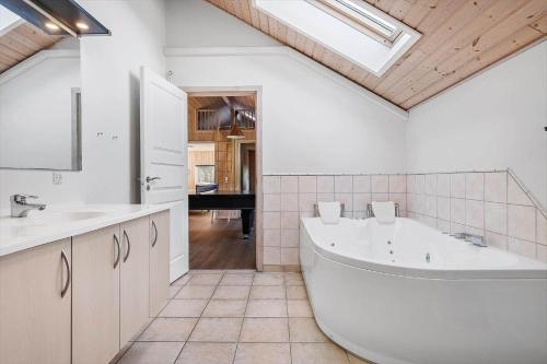 a large white bathroom with a tub and a sink at 0120-Romo-Smafolksvej-61 in Kongsmark