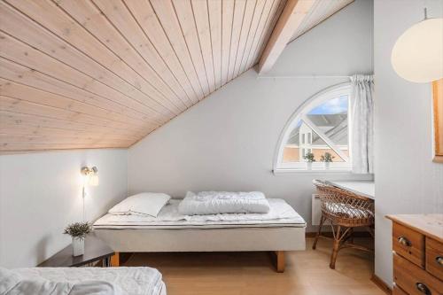 a bedroom with a bed and a window at 0447-Romo-Vestergade-149-B-Ap-120 in Sønderby