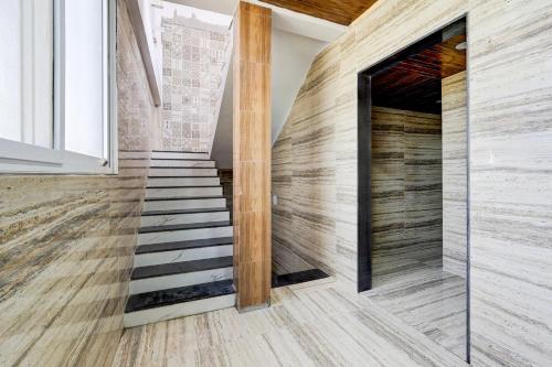 a staircase in a house with a wooden wall at Hotel O PRAMOD GUEST INN in Nellore