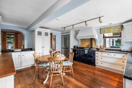a kitchen with a table and chairs in a room at Churchill Country Retreat By My Getaways in Lewes