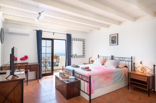Un dormitorio con una cama, un escritorio y un televisor. en Elvira, en Tías