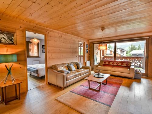 a living room with a couch and a table at Spacieux T4 proche des pistes avec terrasse et parking - 6-8 pers. - FR-1-685-22 in Les Gets