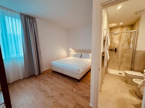 a bedroom with a bed and a bathroom with a shower at Hotel Pex Verona in Verona