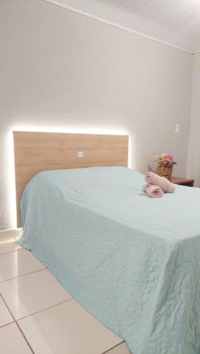 a bed with a pink stuffed animal laying on it at Kitnet Flor do Mar Próximo a Roda Gigante in Ubatuba