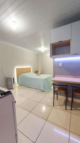 a bedroom with a bed and a desk in it at Kitnet Flor do Mar Próximo a Roda Gigante in Ubatuba