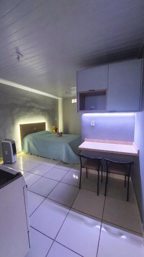 a room with a bed and a table in it at Kitnet Flor do Mar Próximo a Roda Gigante in Ubatuba