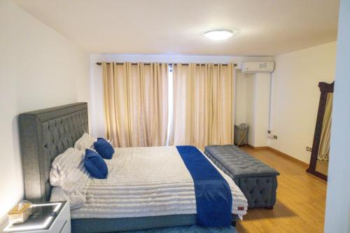a bedroom with a large bed with blue pillows at Fabulous 3-bedroom duplex apartment in Nairobi