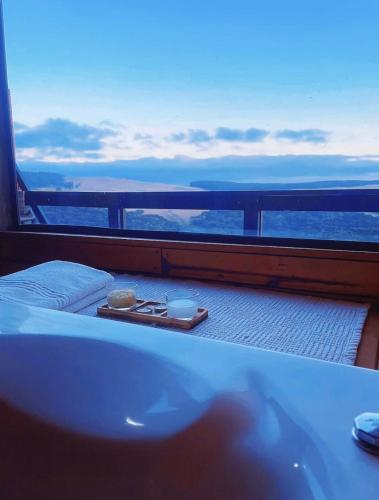 a balcony with a bed and a bath tub on a ship at Canyons Chalet in Cambara do Sul
