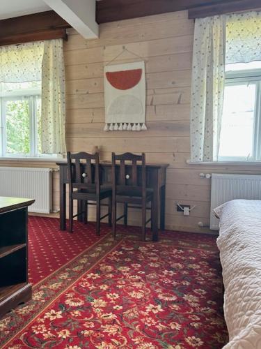 a bedroom with a table and two chairs and a bed at Leśne PoBudki in Białowieża