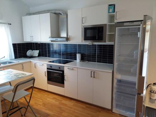 a kitchen with white cabinets and a refrigerator at Apartment Strömstad, Lökholmen in Strömstad