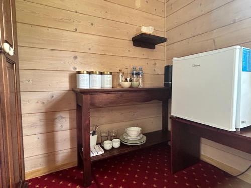 a kitchen with a counter with plates and a refrigerator at Leśne PoBudki in Białowieża