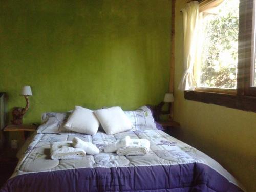 a bedroom with a bed with towels on it at Del Viejo Camino in El Bolsón