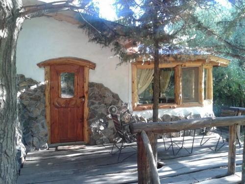 a house with a wooden door and a window at Del Viejo Camino in El Bolsón