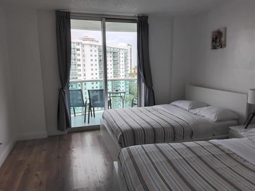 a bedroom with two beds and a large window at Ocean reserve 2 bedroom plus den in Sunny Isles Beach