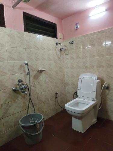 a bathroom with a toilet and a bucket at Alleppey Tharavad in Alleppey