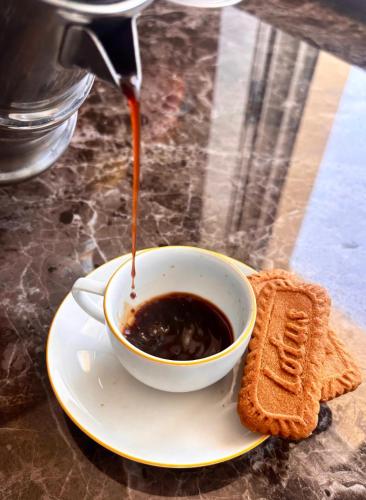 a cup of coffee and a plate with a sandwich at Marlou Health&Fit Club in Buccino