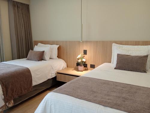 two beds sitting next to each other in a room at Hotel Rulay Medellin in Medellín
