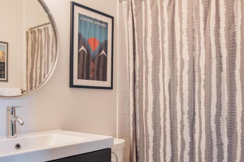 a bathroom with a shower curtain and a sink at Chillside Chalet Modern West Vail Townhouse! in Vail