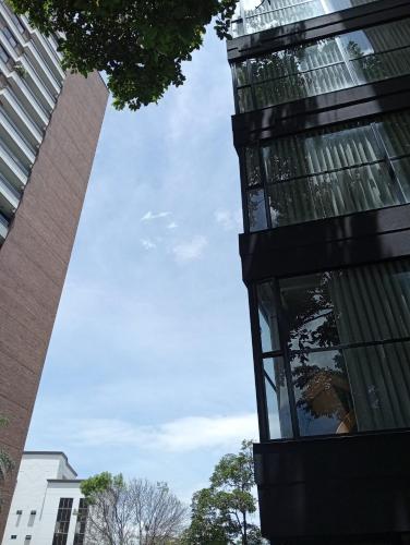 a glass building with the sky in the background at Hotel Rulay Medellin in Medellín