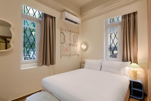 - une chambre avec un lit blanc et 2 fenêtres dans l'établissement Brassbell l Zamalek l Daoud Studios Villa D, au Caire