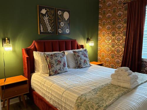 un letto in una camera da letto con pareti verdi di Gilded Magnolia Hideout, Sleeps8, Hot Tub, pet friendly a Savannah