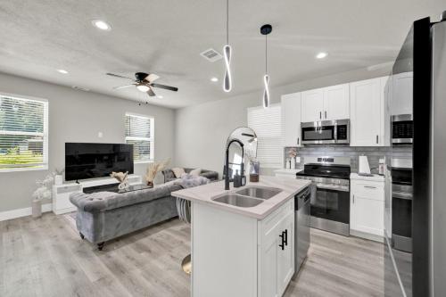 a kitchen and living room with white cabinets at Spacious 3BR Home w Yard Smart TV Parking in Humble