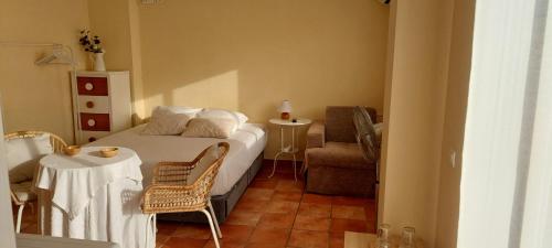 a bedroom with a bed and a chair and a table at Casa Del Sol La Herradura in La Herradura