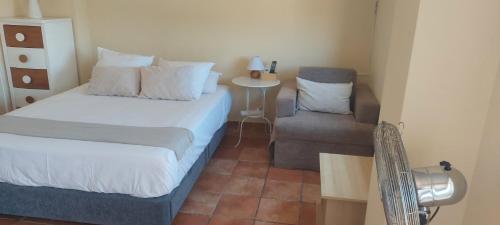 a small bedroom with a bed and a chair at Casa Del Sol La Herradura in La Herradura