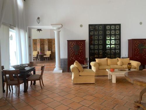 a living room with couches and a table and chairs at Casa Vinca in San Juan Cosalá
