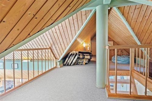 une chambre mansardée avec un plafond en bois et un escalier dans l'établissement 0142-Romo-Ivigtut-1, à Kongsmark