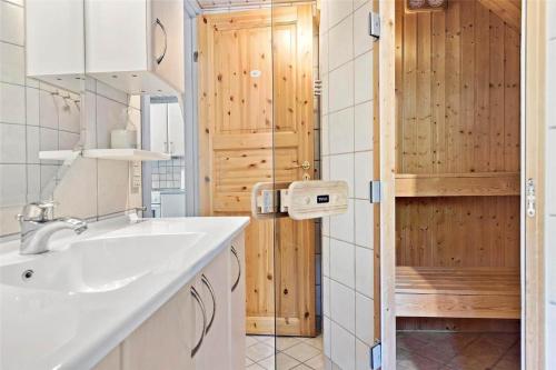 La salle de bains est pourvue d'un lavabo et d'une porte en bois. dans l'établissement 0142-Romo-Ivigtut-1, à Kongsmark