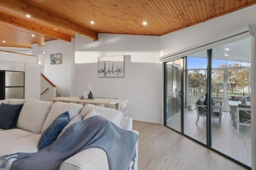 a living room with a white couch and a table at Serenity by the Lake in Rocky Point