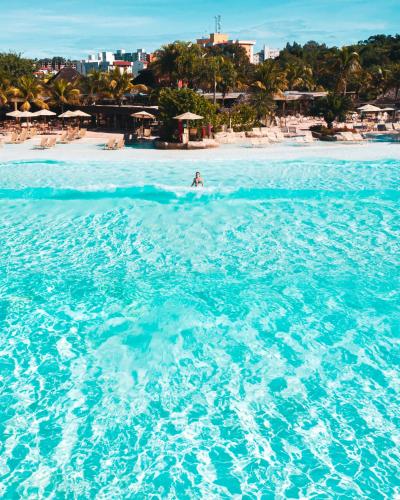 a person riding a wave in the ocean on a beach at Rio Quente Resorts - Hotel Giardino in Rio Quente
