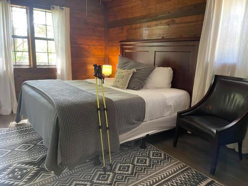 a bedroom with a bed and a chair at Authentic Log Cabin with Full Kitchen, Fireplace a in Eureka Springs
