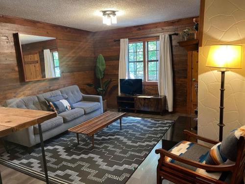 a living room with a couch and a table at Authentic Log Cabin with Full Kitchen, Fireplace a in Eureka Springs