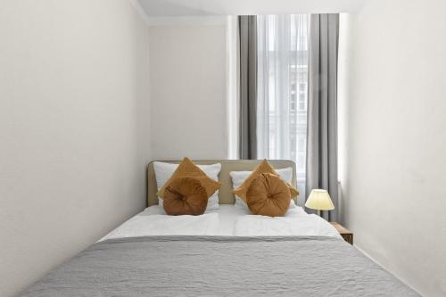 a bedroom with a bed with two pillows and a window at Votivpark Rooms I Self Check In in Vienna