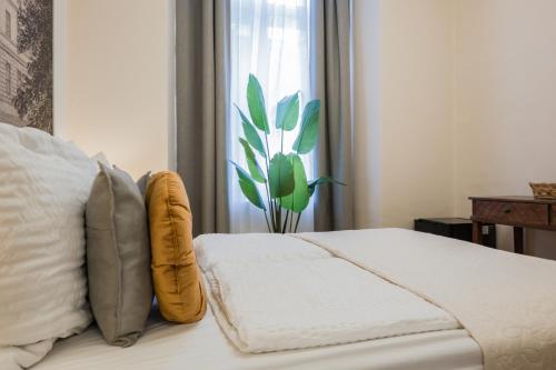 a bedroom with a bed and a window with a plant at Votivpark Rooms I Self Check In in Vienna