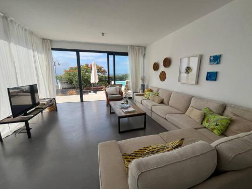 a living room with a couch and a television at Casa en el mar con infinity pool in Punta de Mujeres