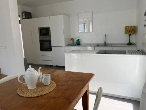 a kitchen with a wooden table with two mugs on it at Casa en el mar con infinity pool in Punta de Mujeres