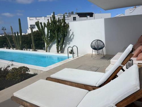 a patio with lounge chairs and a swimming pool at Casa en el mar con infinity pool in Punta de Mujeres