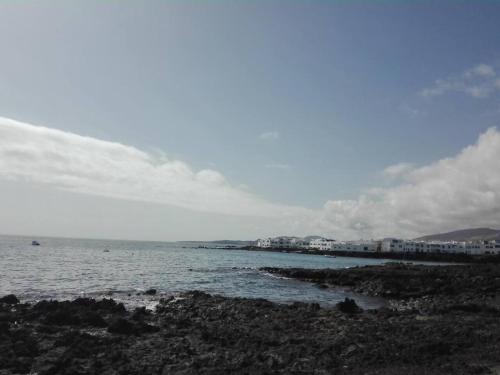 a view of the ocean with buildings in the background at Casa en el mar con infinity pool in Punta de Mujeres