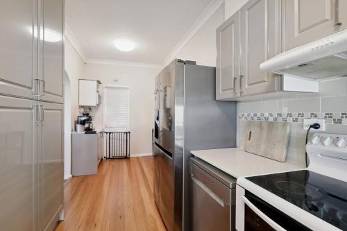 a kitchen with stainless steel appliances and wooden floors at Waterside Whispers in Gorokan