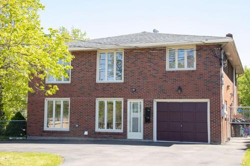 a red brick house with a garage at Tranquil Retreats on Robinson in Moncton