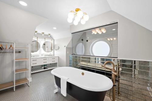 a bathroom with a tub and a large mirror at Monastery Guest House - 1BR Option in Cincinnati