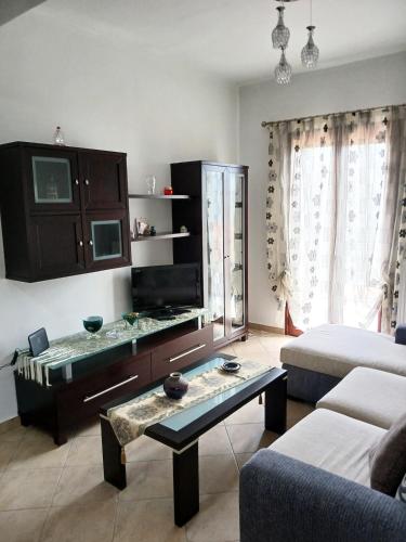 a living room with a table and a couch at Sogno Sulla Montagna in Lagadia