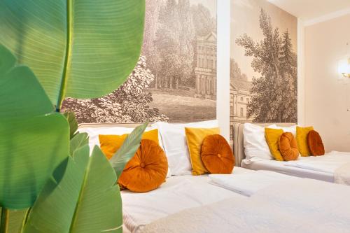 a living room with two white couches with orange pillows at Votivpark Rooms I Self Check In in Vienna