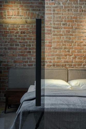 a bed with a glass table in front of a brick wall at Apartamenty Chełmińskie in Chełmno