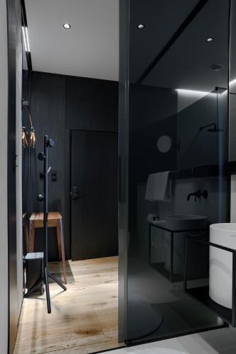 a black bathroom with a sink and a toilet at Apartamenty Chełmińskie in Chełmno