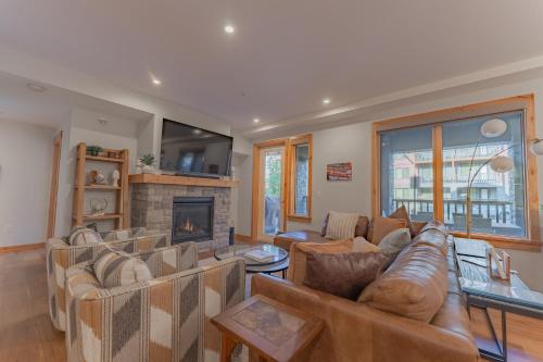 a living room with couches and a fireplace at Timberstone Condo by Canadian Rockies Vacation Rentals in Canmore